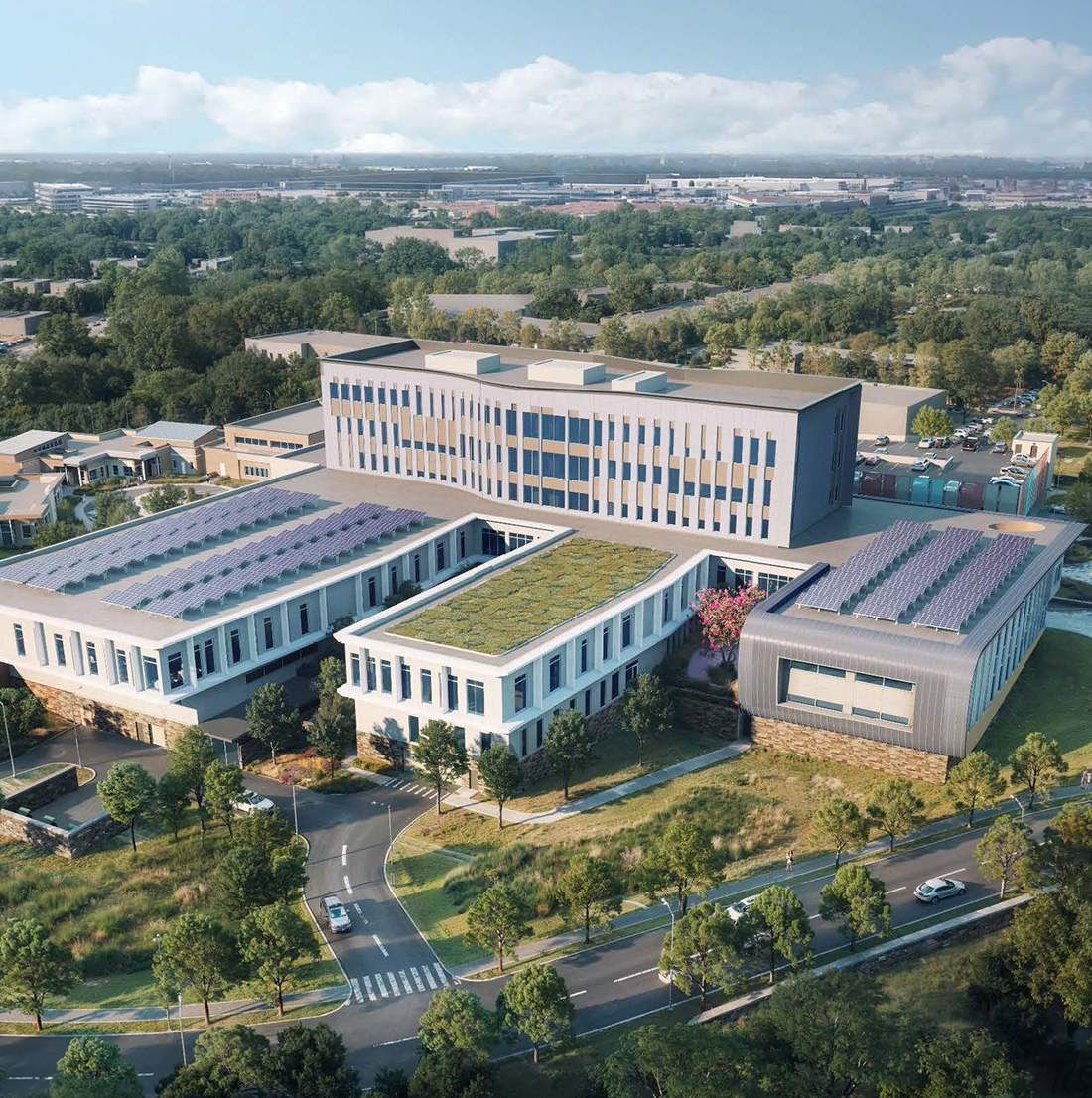 Aerial rendering of a modern campus featuring green roofs, solar panels, and sustainable design elements, surrounded by a tree-lined road network and neighboring buildings.