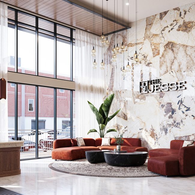 Stylish corner of The Jesse’s lobby with marble wall, tall sheer drapes, red sectional seating, circular black coffee tables, and hanging glass light fixtures beneath a wood ceiling.
